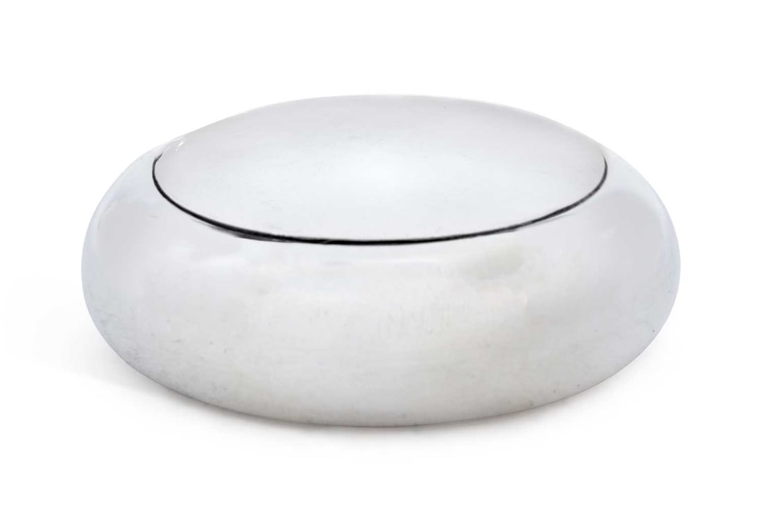 AN EDWARDIAN SILVER POWDER BOX: by E. S. Barnsley & Co. (Edward Souter Barnsley), Birmingham 1901, of plain compressed circular form, with sprung hinged cover and gilt wash interior. 7.2cm diameter, 2.2 troy ounces Good condition ov