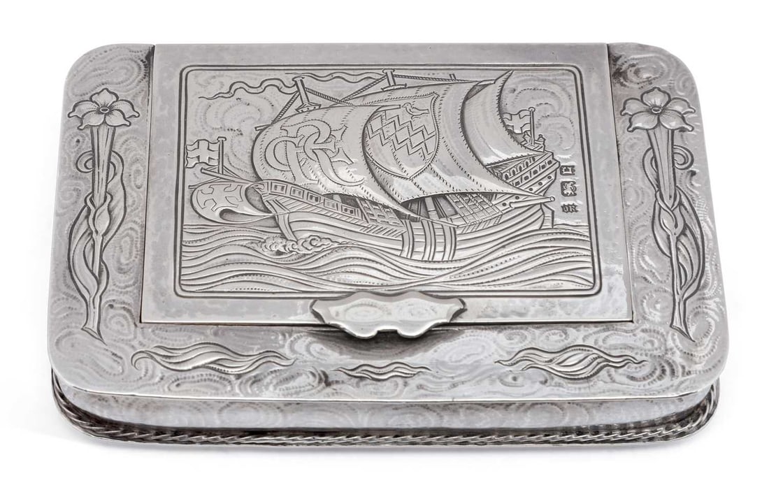 OMAR RAMSDEN: A RARE ARTS & CRAFTS GEORGE V SILVER TOBACCO OR SNUFF BOX: London 1918, of oblong form, the hinged cover finely chased with a three-masted sailing vessel at sea, the mainsail monogrammed 'CRE', second sail with a coat of arms, within a plain border, further d