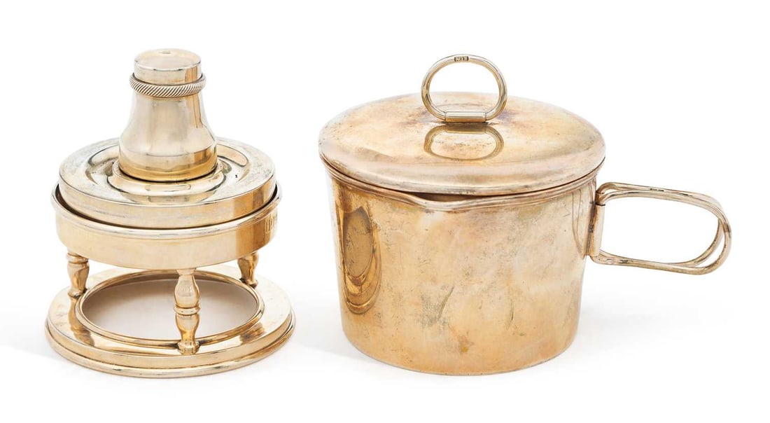 AN EDWARDIAN SILVER TRAVELLING MUG AND SPIRIT BURNER: by Charles Henry Dumenil, London 1904, comprising a cylindrical mug with folding handle and cover, together with a spirit burner and stand, in original fitted leather case. 6.5cm high, 10.3 troy