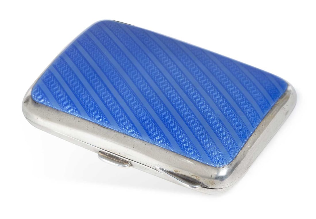 A GEORGE V SILVER AND ENAMEL CIGARETTE CASE: by Robert Chandler, Birmingham 1912, rectangular form, with a diagonal striped motif beneath blue enamel. 8.5cm by 6.5cm, 3.1 troy ounces