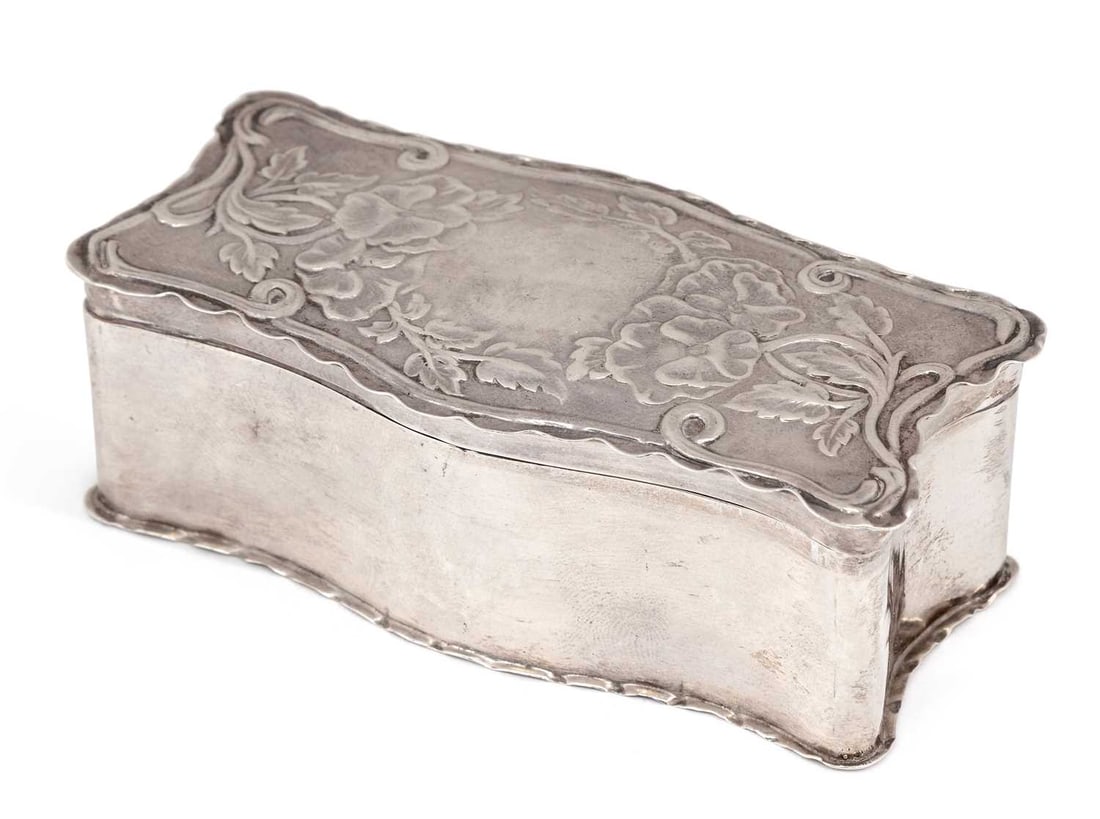 AN ART NOUVEAU SILVER TRINKET BOX: maker's mark rubbed, Chester 1902, of shaped rectangular form, the hinged cover repousse decorated with foliage, with shaped borders. 10cm by 5cm by 3.5cm, 2.5 troy ounces