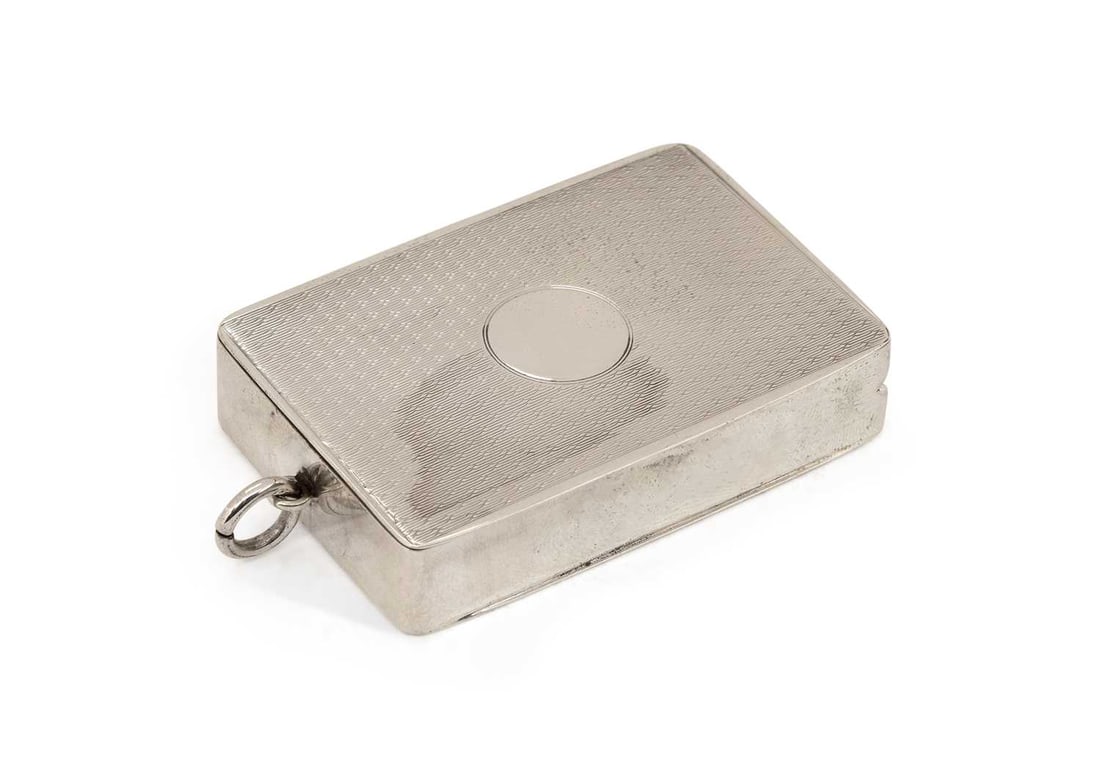 A GEORGE V SILVER VESTA CASE: by Hasset & Harper Ltd., Birmingham 1919, of rectangular form with hinged cover, the front with engine-turned decoration and vacant cartouche. 6.5cm by 4.5cm (excl. suspension loop), 1.6 troy ounces