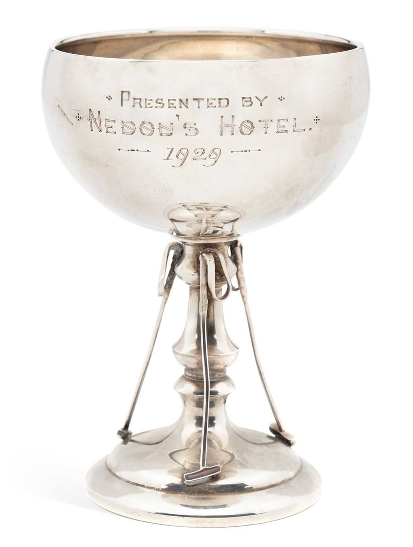 A GEORGE V SILVER PRESENTATION POLO TROPHY CUP: by William Davenport, Birmingham 1928, the shallow circular bowl above a knopped stem and three polo mallets, on a circular stepped base, engraved inscription Presented by Nedou's Hotel 1929. 13.2cm