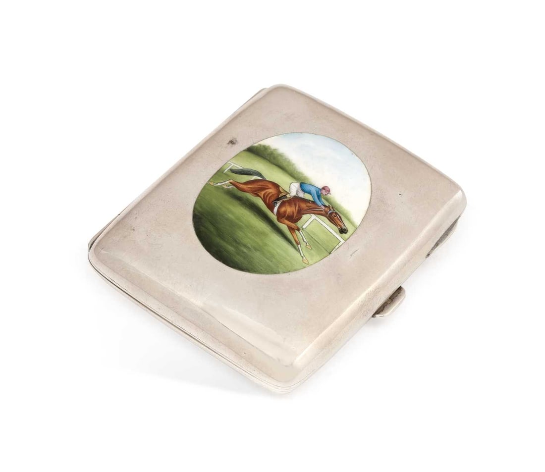 AN EDWARDIAN SILVER AND ENAMEL CIGARETTE CASE: by Albert Sydenham, Birmingham 1908, of rectangular form, the hinged cover enamelled with an oval hand painted with a race horse and jockey, with gilt wash interior. 8cm by 7cm, 2.9 troy ounces Good