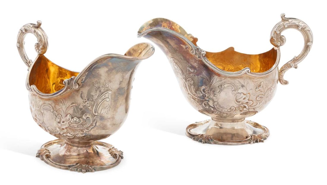 A PAIR OF LARGE VICTORIAN SILVER SAUCEBOATS: by Henry Wilkinson & Co., Sheffield 1854, each of oval form with shaped scroll border and foliate chased decoration, acanthus leaf-form scroll handle and silver-gilt bowl, on a domed oval foot with