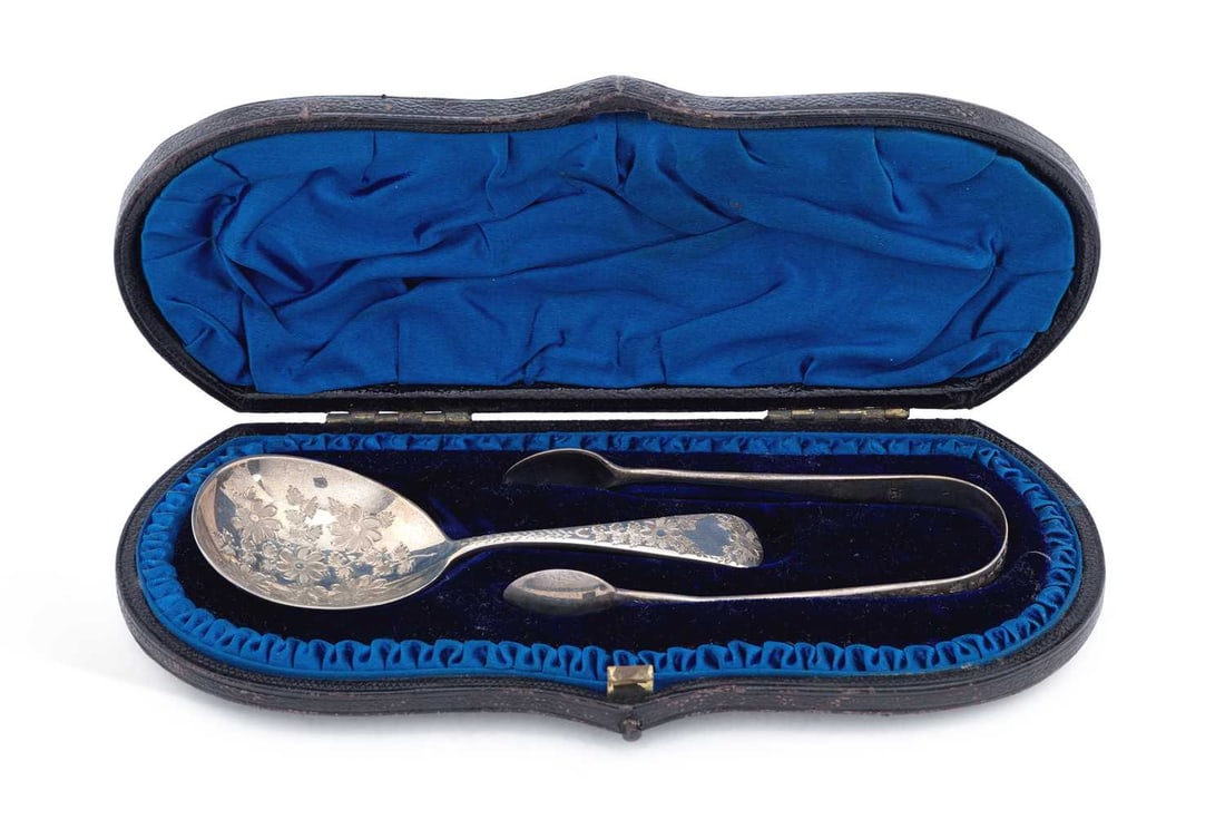 A LATE VICTORIAN SILVER SPOON AND SUGAR TONG SET: by Wakely & Wheeler, London 1895, foliate engraved, in fitted case. Spoon 10cm long. Gross weight of silver 0.99 troy ounces Good condition - case with light wear to base.