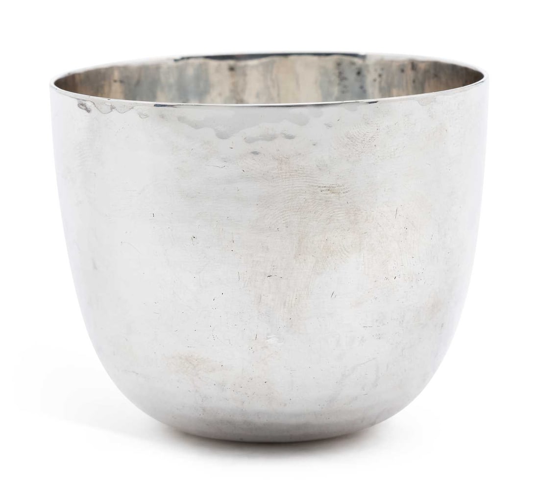 A LATE VICTORIAN SILVER TUMBLER CUP: by Wakely & Wheeler, London 1899, of typical form with hammered decoration, bearing rubbed retailers mark to base. 6.5cm high, 5.5 troy ounces Good condition in commensurate with age. Light surface