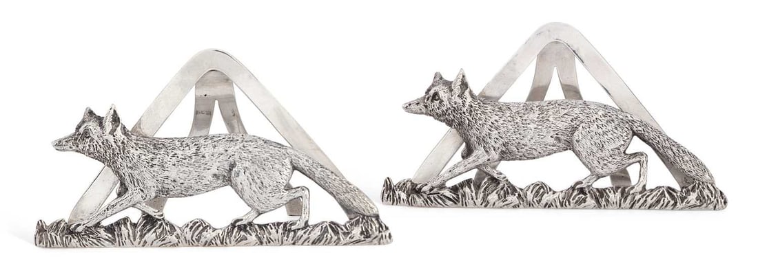 A PAIR OF VICTORIAN SILVER FOX MENU HOLDERS: by Horton & Allday, Birmingham 1899, of triangular form, each a realistically cast figure of a running fox. (2) 6.5cm high, 5.1 troy ounces gross