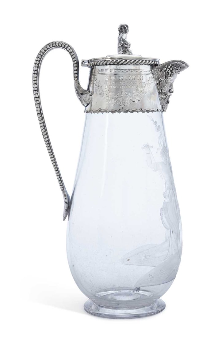 A LATE VICTORIAN SILVER-MOUNTED CUT GLASS AND ETCHED CLARET JUG: by W. Spurrier & Co., Birmingham 1891, the hinged cover with rope-twist rim and figural finial, mask spout, beaded border to handle, presentation inscription W. Morton, from his Friend S. Martin