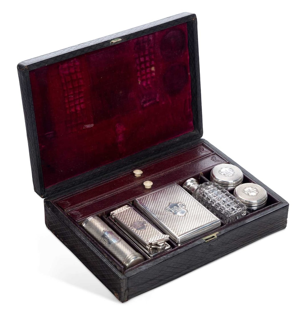 CITES - A VICTORIAN SILVER COVERED GENTLEMAN'S TRAVELLING VANITY SET: by Frances Douglas, London 1854, within a fitted leather case, comprising five silver lidded cut-glass jars with engine-turned decoration, and a silver shaving brush, each with shield cartouche