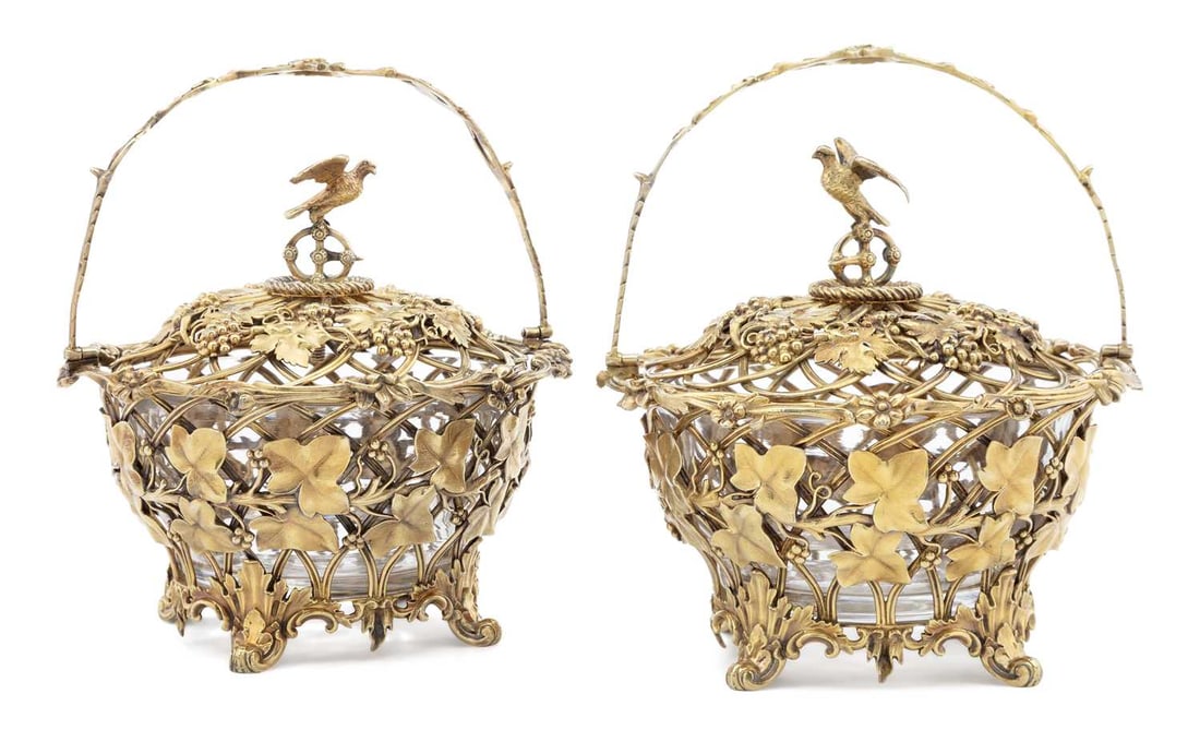 A PAIR OF VICTORIAN SILVER GILT-MOUNTED GLASS SWEETMEAT BASKETS: by Edward, Edward junior, John & William Barnard, London 1845, the mounts pierced and cast with trailing vine and ivy, each with a swing handle and domed cover surmounted by a bird finial, on rococo