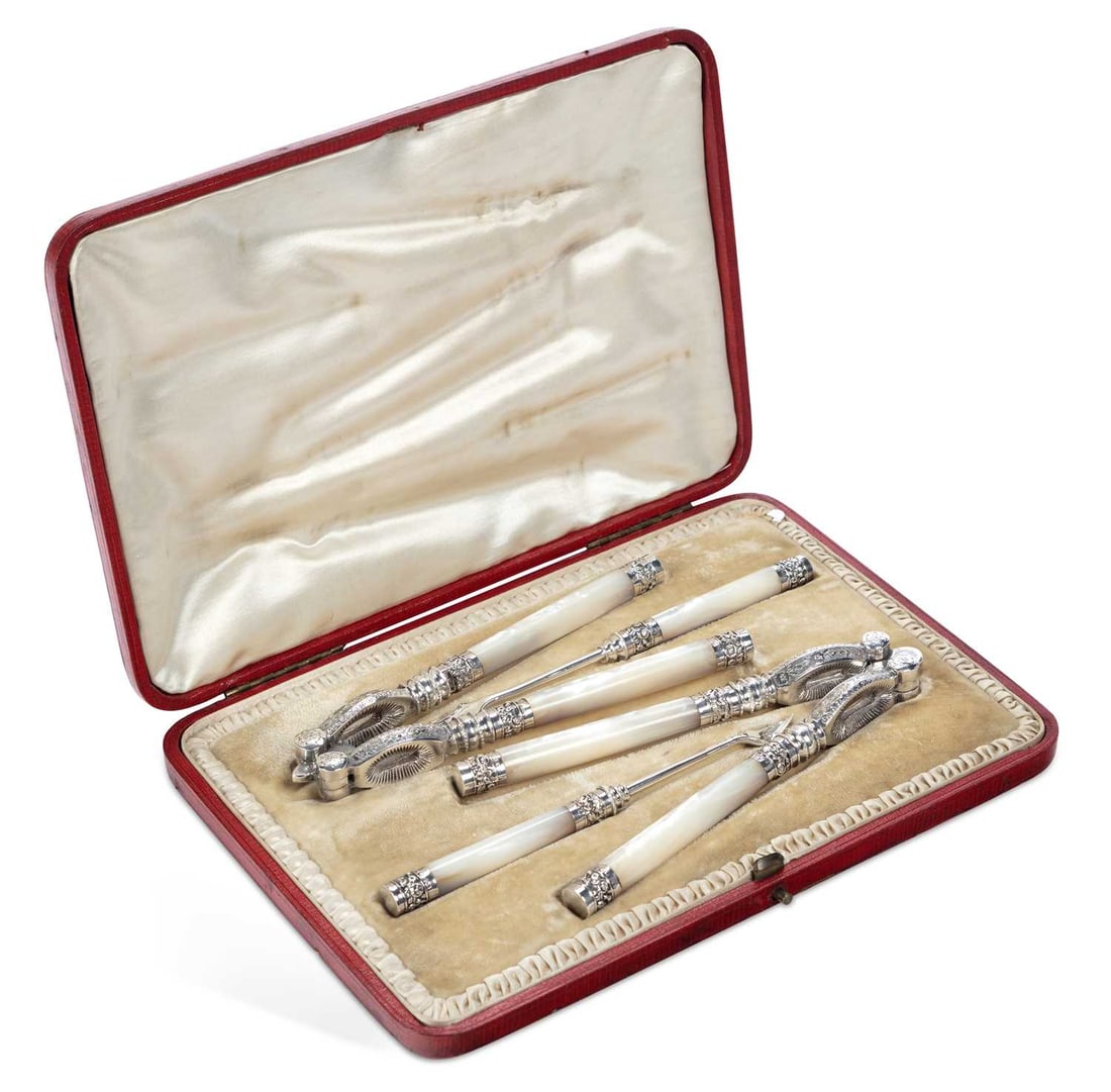 A LATE VICTORIAN SILVER AND MOTHER-OF-PEARL CASED NUTCRACKER SET: by Levesley Brothers, Sheffield 1898, the case containing two pairs of silver-mounted nutcrackers and two silver-mounted nut picks, each foliate chased and engraved, with plain handles, within a