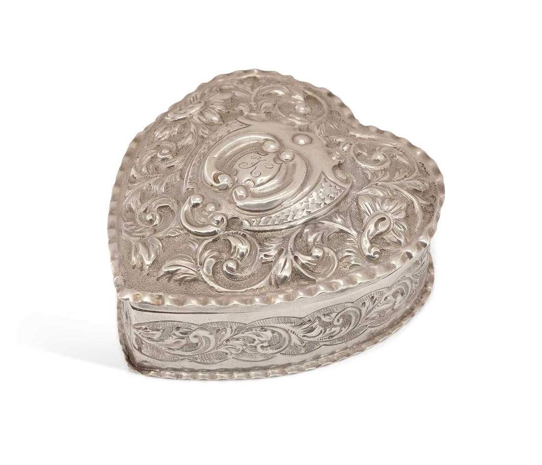 A LATE VICTORIAN SILVER TRINKET BOX: by George Unite, London 1890, heart-shaped with fitted cover, with repousse foliate scroll decoration and crimped borders, presentation inscription to base Kathleen Dunham, Baptised April 3rd 1892 fro