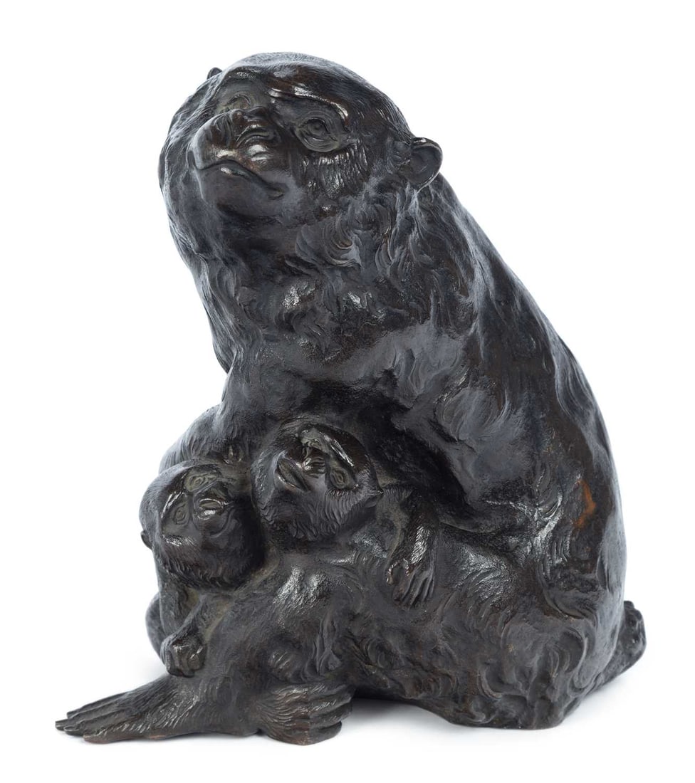 A JAPANESE BRONZE GROUP OF MONKEYS MEIJI PERIOD: modelled as a macaque with two young clambering beside her, one looking up and one clinging beneath, naturalistically cast with finely chased fur, with an incised signature. 21cm high