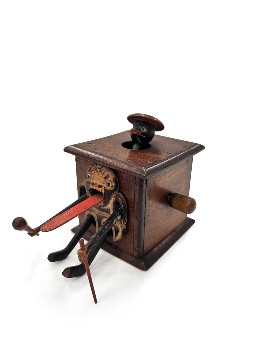 A JAPANESE KOBE TOY MEIJI PERIOD: amusingly carved as a man emerging from a box, holding a club and a stick. 6.2cm high
