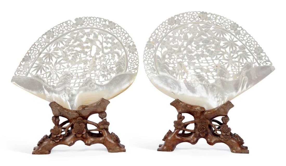 A PAIR OF CHINESE CARVED MOTHER-OF-PEARL SHELL TABLE SCREENS 19TH CENTURY: each carved and pierced with birds among prunus, bamboo and peony issuing from rockwork, within a pierced border of flowering branches and scrolls, the lower part left as natural nacre, on carved hard