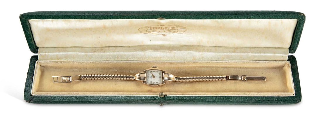 A LADY'S 9CT GOLD TUDOR BRACELET WATCH: the silvered tonneau dial signed Tudor, with gilt Arabic indices and sword hands, plain crown, integral Brazilian link bracelet with fancy case lugs, snap and ladder catch signed Rolex with expanding 