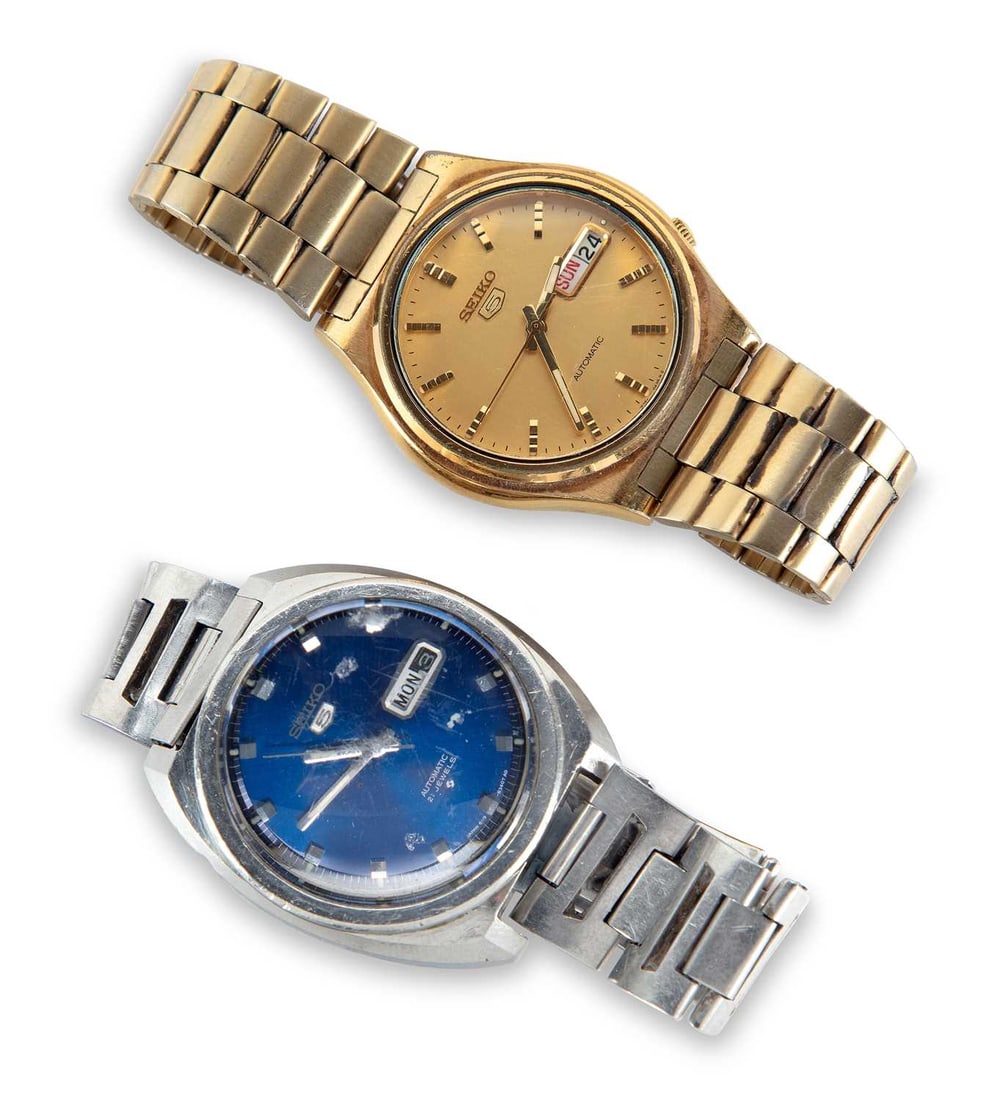 TWO SEIKO WATCHES: comprising a gold-plated Seiko 5 automatic day date watch on integral bracelet; and a steel Seiko 5 automatic day date with a blue dial on a Seiko bracelet. (2) Last case diameter 39mm Watches are