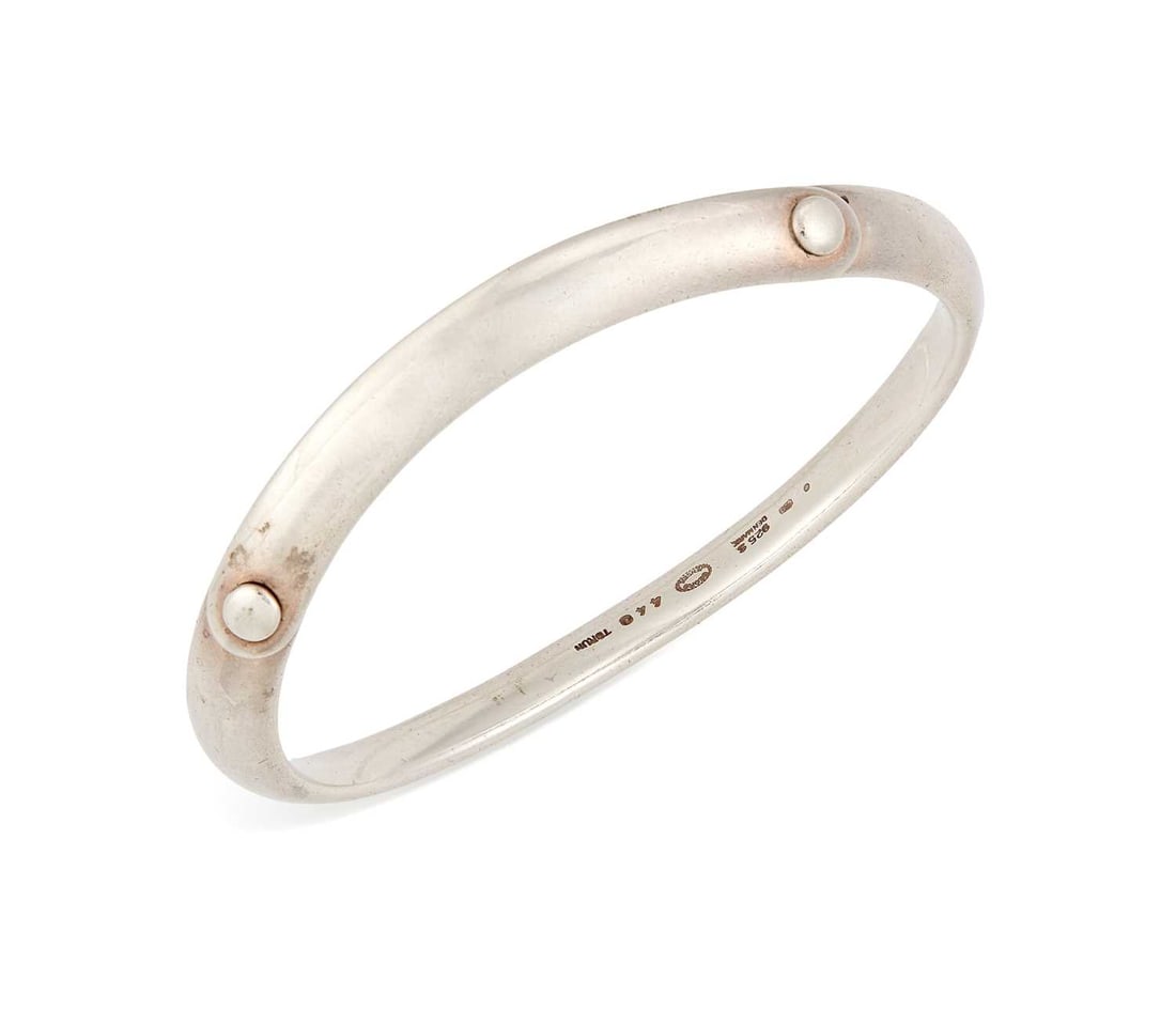 VIVIANNA TORUN BULOW-HUBE FOR GEORG JENSEN, A DANISH SILVER BUTTON BANGLE: model 440, with button clasp, stamped '925S'. 18cm inner diameter, 41 grams Light surface wear