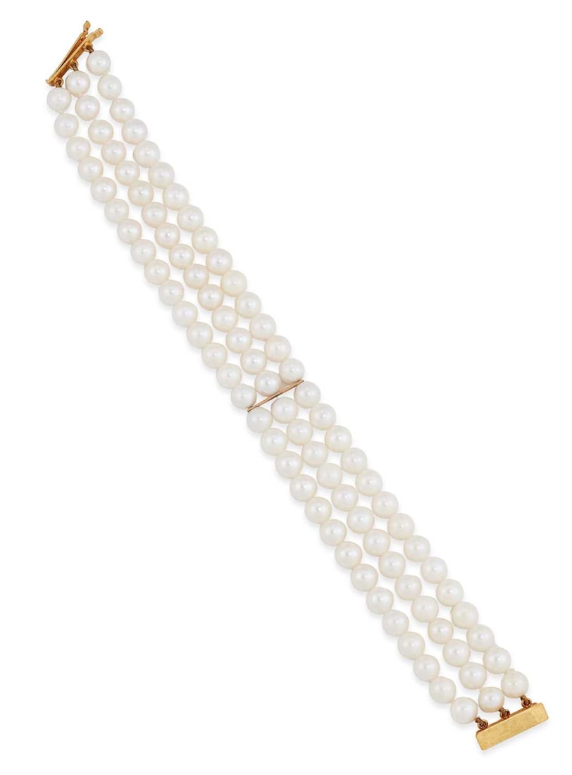 A CULTURED PEARL BRACELET: three rows of uniform cultured pearls tied by bar links, with a bar clasp, stamped '375'. 19cm long, 2cm wide, 36 grams Good condition