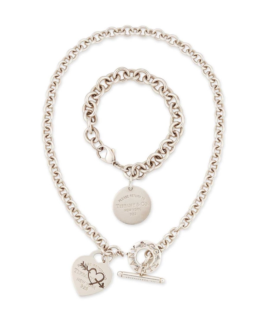 TIFFANY & CO, A SILVER 'RETURN TO TIFFANY' NECKLACE AND BRACELET: the necklace with an etched heart and arrow heart tag, hallmarked; the bracelet with a circular tag, hallmarked. (2) Necklace 42cm long, bracelet 18cm long, 95 grams gross Good condition