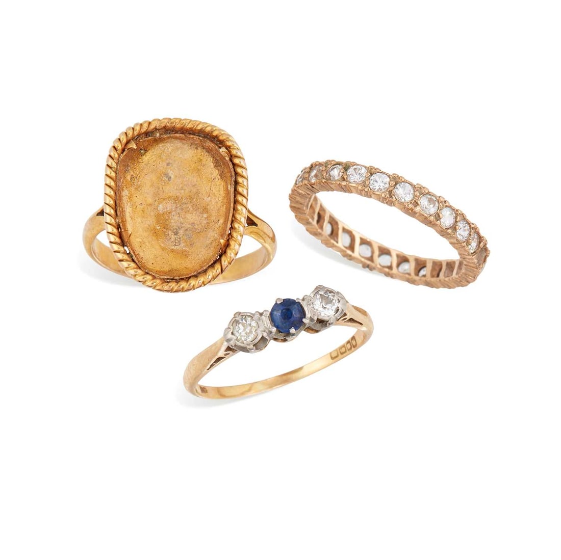 THREE RINGS: comprising an 18 carat gold sapphire and diamond three stone ring, hallmarked; a white stone eternity ring, stamped '9CT'; and a ring with a vacant setting, stamped '9CT'. (3) Abrasion to the sapphire