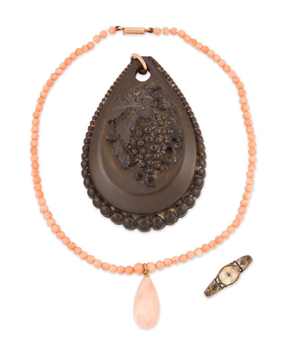 A GROUP OF ANTIQUE JEWELLERY: comprising a Vulcanite grape vine pendant; a black dot paste ring; and a coral pendant necklace. (3) Pendant 6.5cm long, ring size O1/2, ring 1.9 grams Tip of vulcanite pendant chipped. Some abrasion