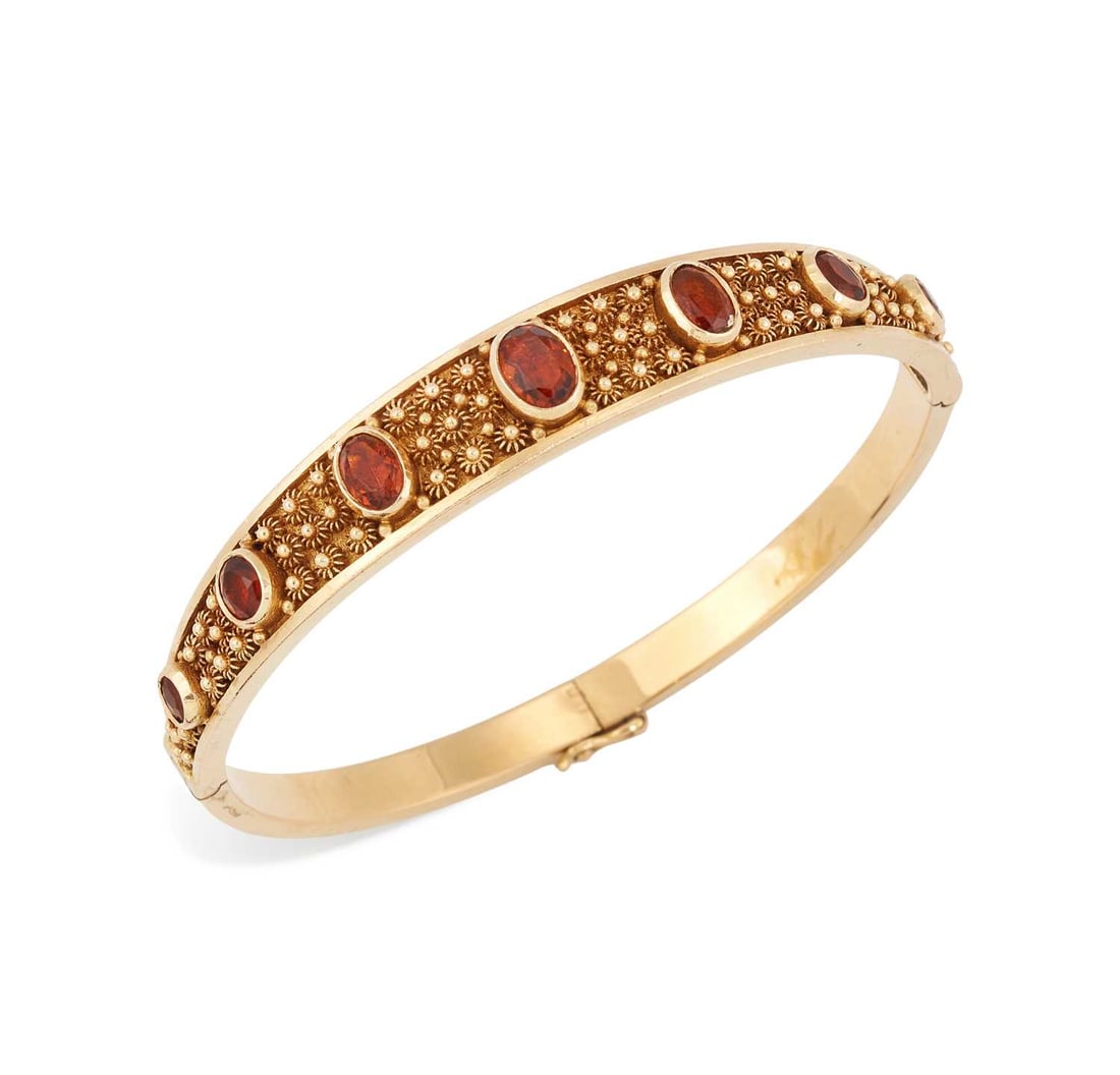 A VICTORIAN ETRUSCAN REVIVAL CITRINE HINGE OPENING BANGLE: graduated oval-cut citrine to a tapering cannetille front, unmarked. 17cm inner circumference, 20.8 grams Light general wear, some play in the hinge