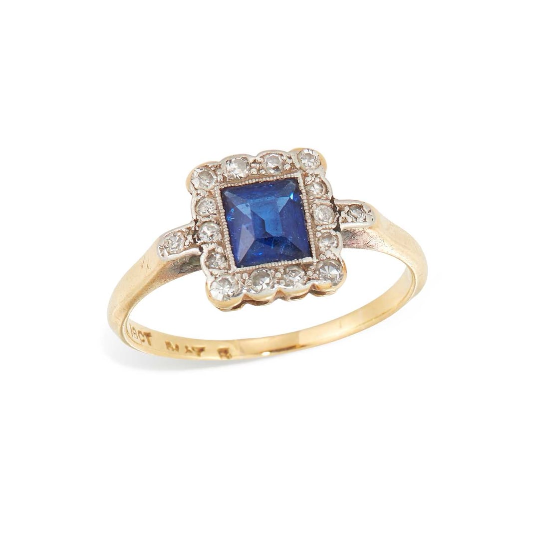 A SAPPHIRE AND DIAMOND CLUSTER RING: an octagonal-cut sapphire within rectangular border of milgrain-set diamonds, stamped '18CT'. Ring size O1/2, 2.9 grams Light abrasion to the sapphire