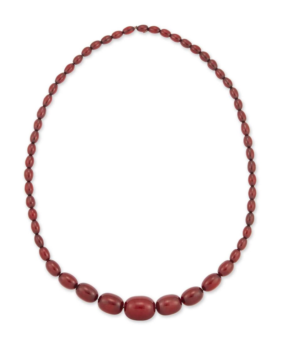 A CHERRY AMBER BAKELITE BEAD NECKLACE: formed of fifty-five barrel-shaped beads, with a screw clasp. 88.5cm long, 63 grams No clasp, one continuous length. Beads with internal streaking