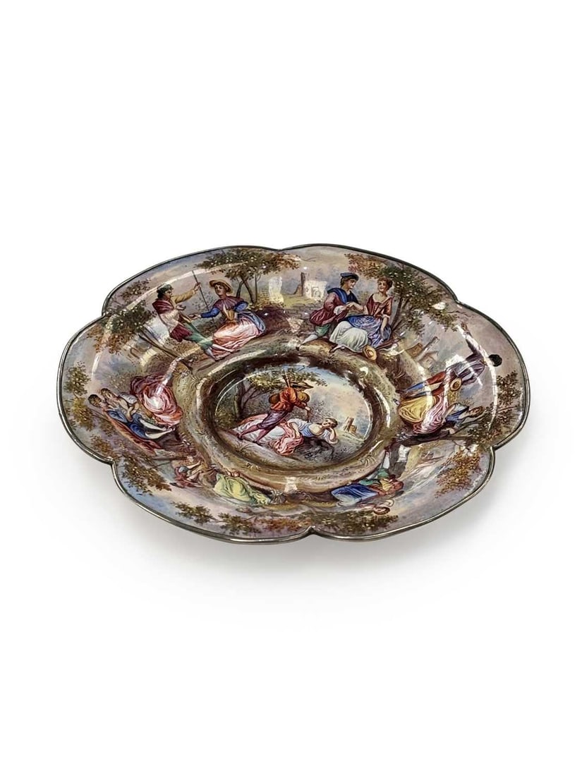 A VIENNESE ENAMEL AND SILVER MOUNTED DISH 19TH CENTURY: marked A, the dish or stand of lobed shape, painted with pastoral scenes of courting couples, and with scenes of castles and ruins to underside. 12.2cm wide