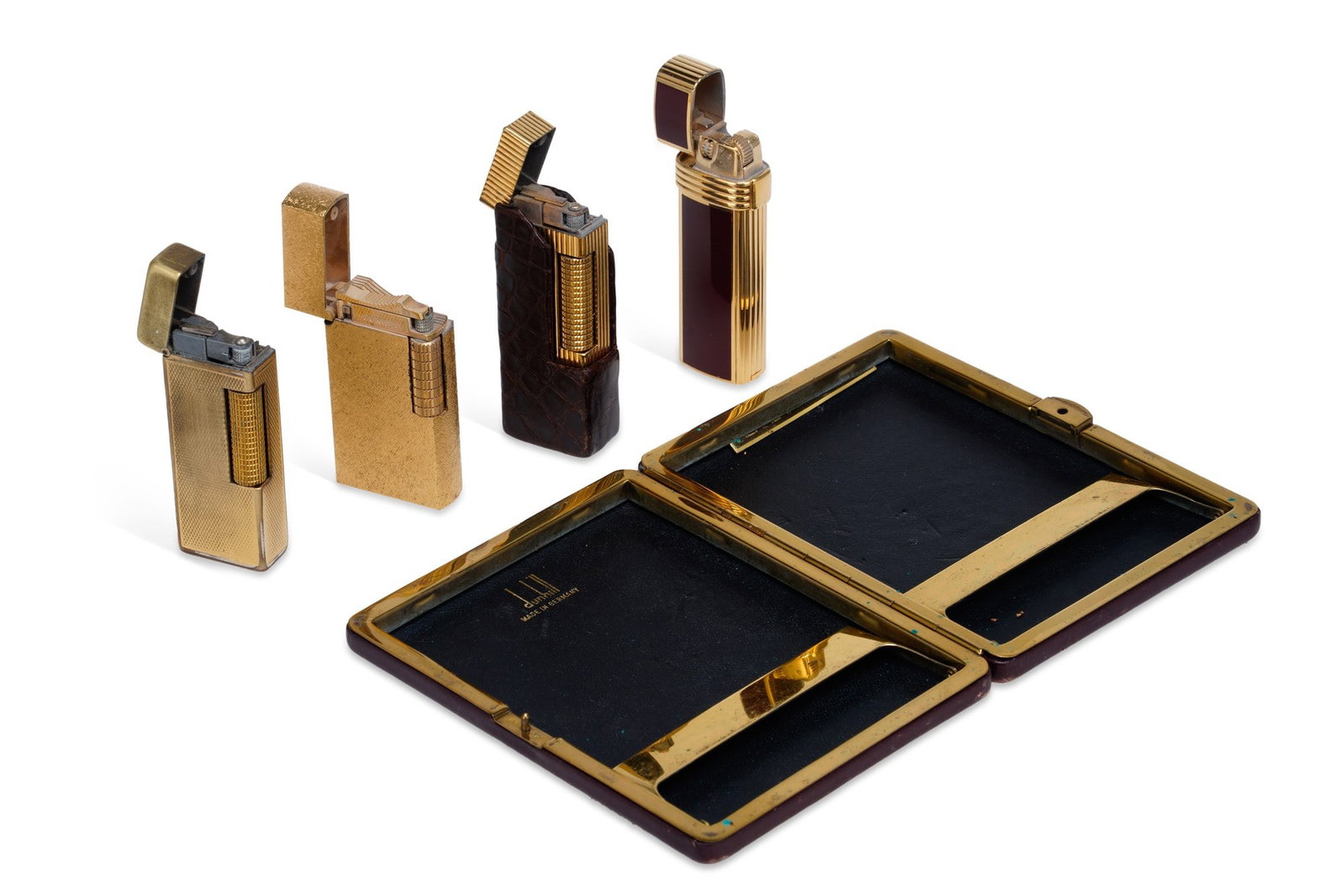 A GROUP OF LIGHTERS: including a Dior lighter, gold-plated with oxblood enamel panels; two Dunhill Rollagas, with textured, linear and diamond decoration, one with a fitted crocodile skin effect leather sleeve; and a Dunh