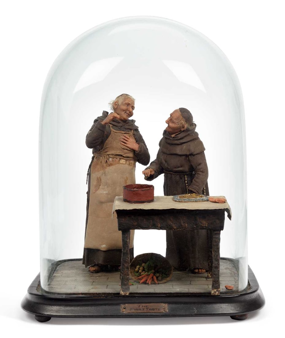 A WAX AND MIXED-MEDIA FIGURAL DIORAMA 'THE FIRST TASTE': modelled as two jovial friars standing beside a table laid with food, raised on an ebonised rectangular base with an applied title plaque and glass dome. 35.5cm high overall
