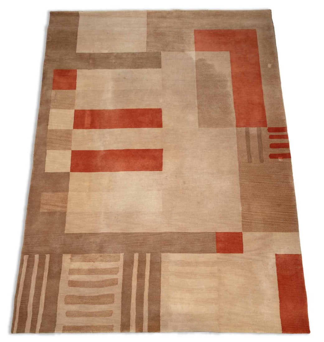 A LARGE MODERN WOOL CARPET: in the Art Deco taste, of asymmetric geometric design in shades of beige, camel, brown and terracotta, one end with a panel of banded stripes. 355cm by 270cm