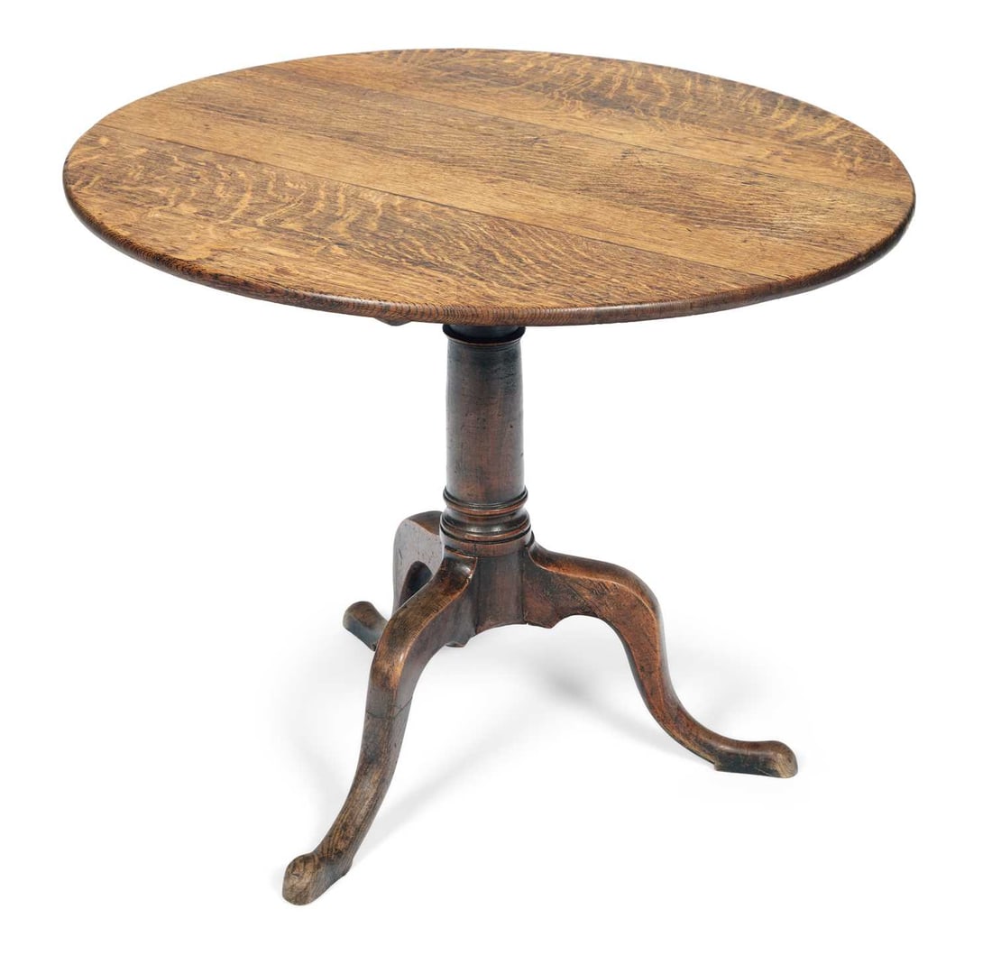 A GEORGE III OAK TRIPOD TABLE: the circular tilting top with a moulded edge, on a turned tapering column with a collar, the tripod base with cabriole legs terminating in pad feet. 71.5cm high, 85cm diameter