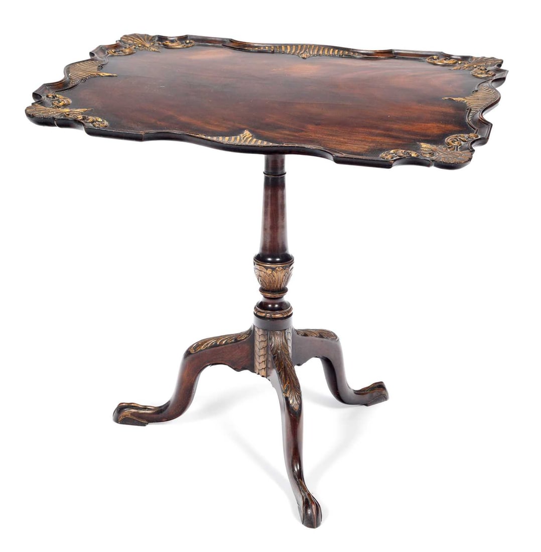 A 19TH CENTURY PARCEL-GILT AND CARVED MAHOGANY TILT-TOP TRIPOD TABLE: the shaped rectangular top raised on a slender tapering stem continuing to downswept legs terminating in claw feet. 69cm high, 75cm wide, 63cm deep