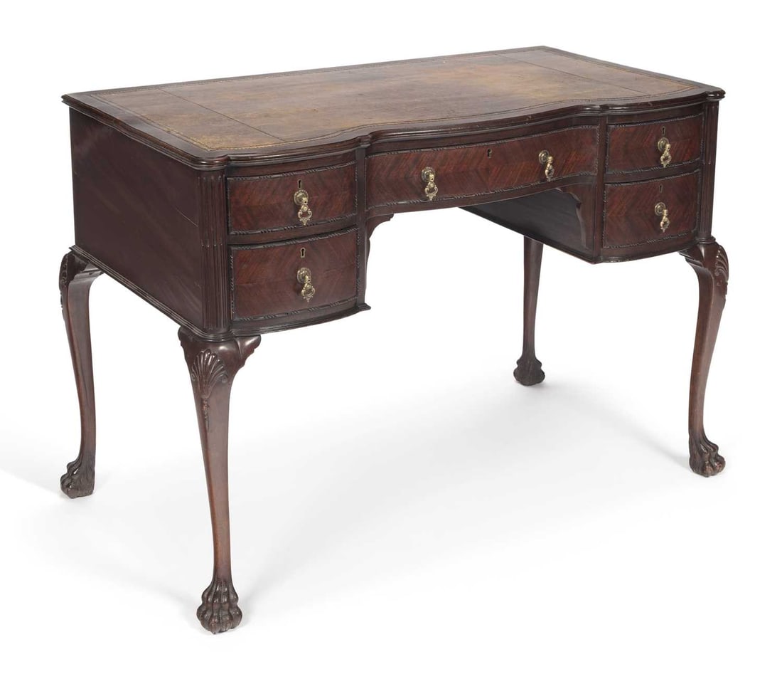A MAHOGANY SERPENTINE WRITING TABLE STAMPED EDWARDS & ROBERTS: in the George II taste, the serpentine top inset with a tooled leather writing surface, above a frieze drawer flanked by two banks of two bowfront drawers with brass handles, the canted angles