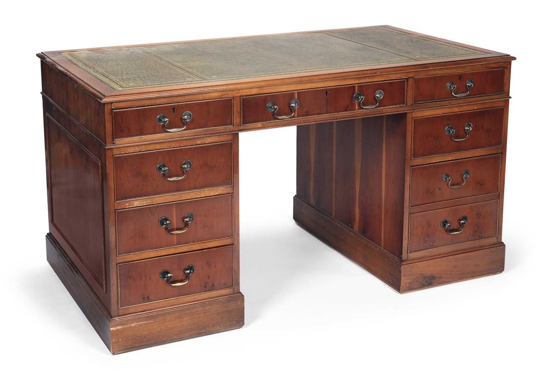 A GEORGIAN STYLE YEW WOOD TWIN PEDESTAL DESK: the rectangular top inset with a green gilt-tooled leather writing surface, above three frieze drawers, each pedestal fitted with three graduated drawers with brass swan neck handles, on plinth bases.
