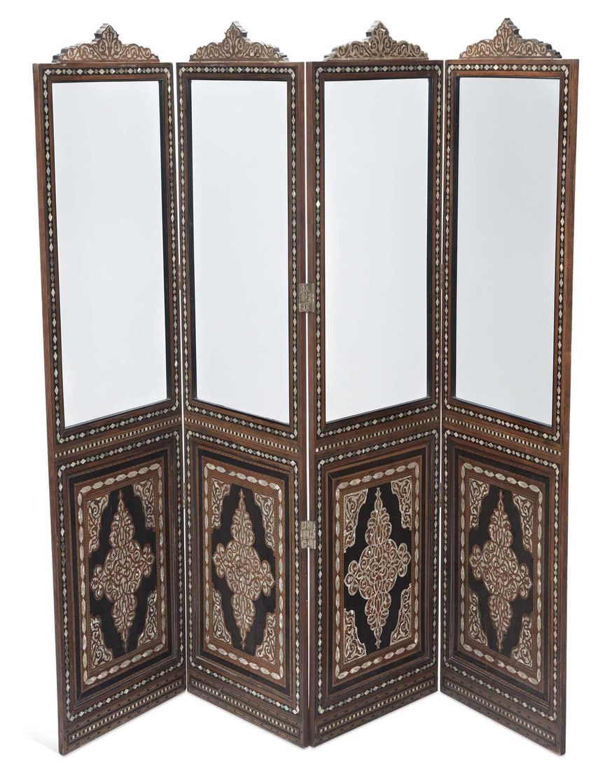 A SYRIAN MOTHER-OF-PEARL AND ABALONE INLAID FOUR-FOLD SCREEN: each fold with a shaped and pierced cresting above a bevelled mirror plate, the lower panel inlaid with an arabesque medallion and spandrels on an ebonised ground, within borders of mother-of-pearl an