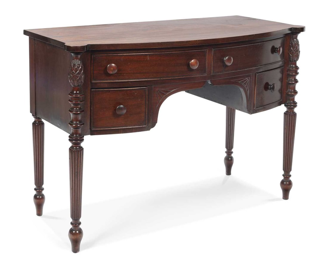 A REGENCY STYLE MAHOGANY BOW-FRONT SIDE TABLE: with four drawers, raised on reeded tapering legs. 77cm high, 110cm wide, 52cm deep