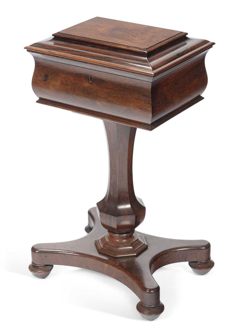 A WILLIAM IV ROSEWOOD TEAPOY: the hinged rectangular top opens to reveal a fitted interior, raised on a faceted stem issuing from a quadform platform base with turned feet. 79cm high, 43cm wide, 33cm deep