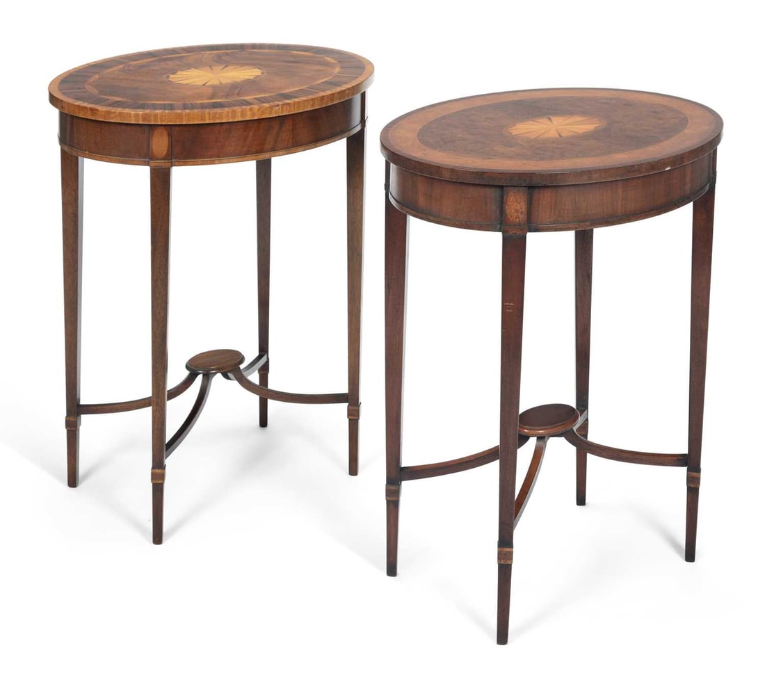 A NEAR PAIR OF EDWARDIAN INLAID MAHOGANY OVAL OCCASIONAL TABLES: each with an oval top inlaid with a fan paterae within crossbanding and stringing, raised on square tapering legs joined by shaped stretchers centred by an oval platform, one with a burr veneered fiel