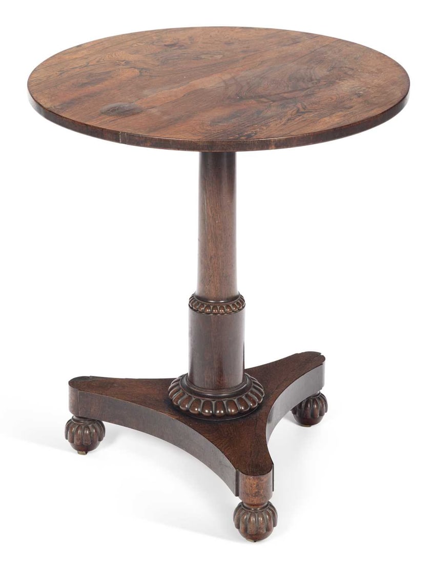 A WILLIAM IV ROSEWOOD OCCASIONAL TABLE: the circular top in well figured veneers, raised on a turned cylindrical column with a gadrooned collar, on a concave sided triform platform base with gadrooned bun feet. 70cm high, 61cm diameter