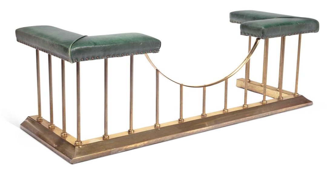 AN EDWARDIAN BRASS CLUB FENDER: the rectangular kerb with a bowed central rail raised on turned uprights, the ends with green upholstered seats with close nailing. 52cm high, 162cm long, 60cm deep
