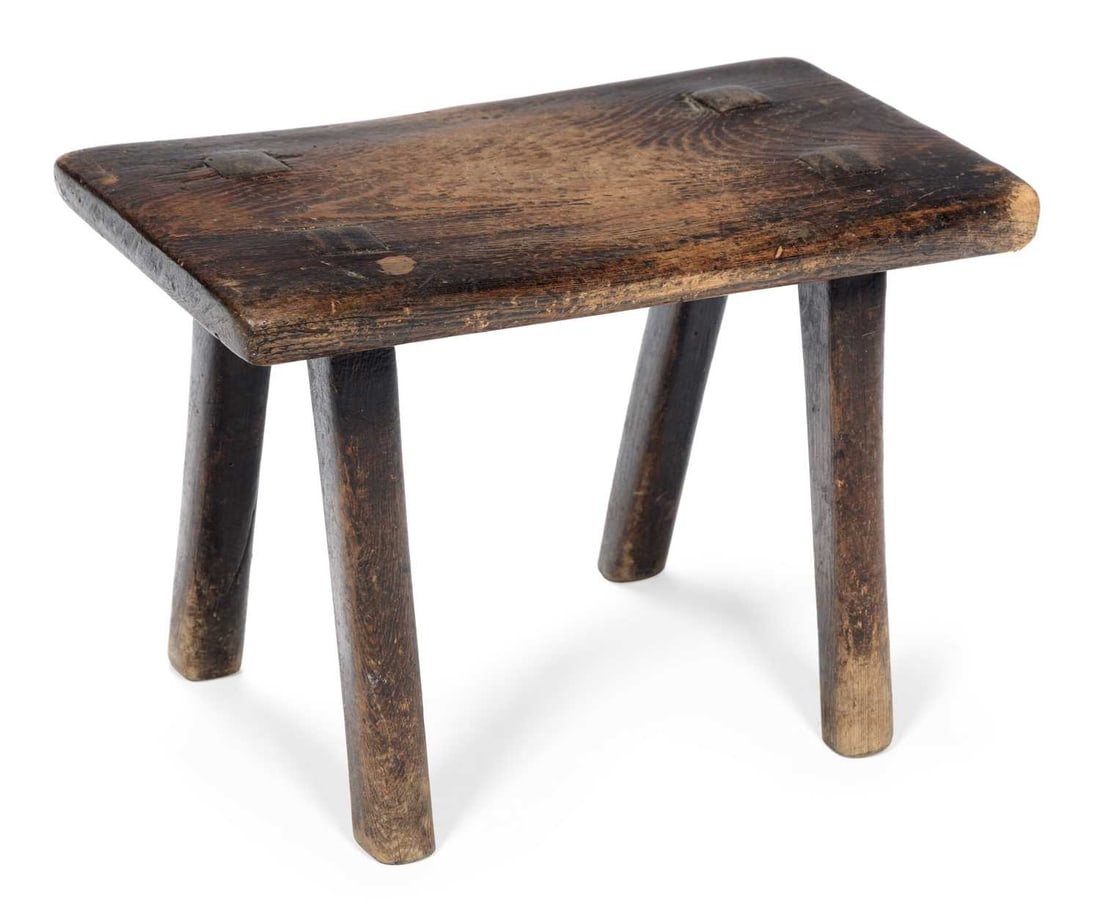 A SCOTTISH CREEPIE STOOL: the rectangular plank seat with wedged through tenons, raised on four splayed and whittled legs. 36cm wide