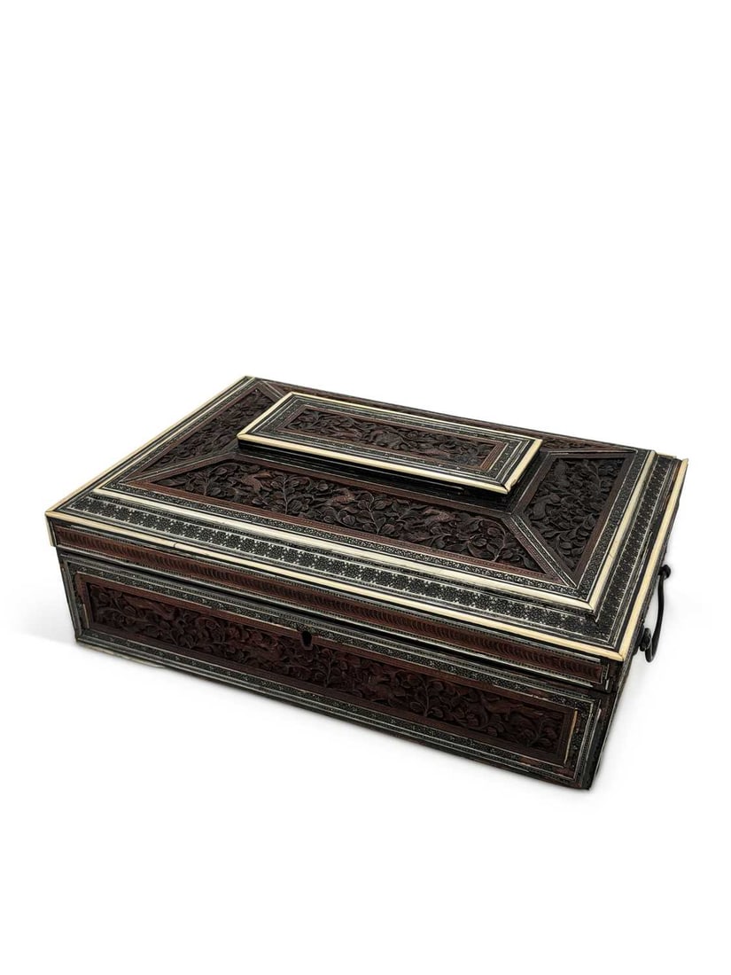 CITES - AN ANGLO-INDIAN CARVED SANDALWOOD AND SADELI INLAID WORK BOX 19TH CENTURY: of rectangular form with a stepped and canted cover, densely carved throughout with birds and animals among flowering foliage, within sadeli micromosaic bands and pale stringing, opening to a