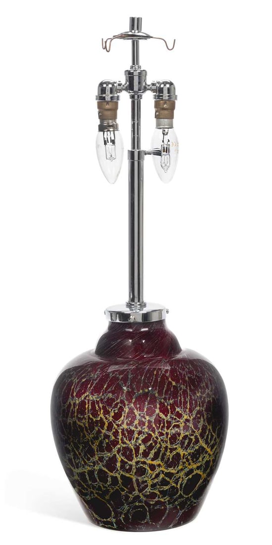 A WMF IKORA GLASS TABLE LAMP CIRCA 1930: A WMF IKORA GLASS TABLE LAMP CIRCA 1930 the shouldered aubergine glass body with yellow-green webbed decoration, fitted with chrome-plated mounts and twin light fittings. 61cm high