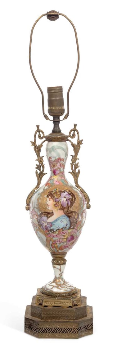 A FRENCH GILT METAL MOUNTED PORCELAIN LAMP CIRCA 1915: A FRENCH GILT METAL MOUNTED PORCELAIN LAMP CIRCA 1915 decorated in Art Nouveau taste, with a girl amongst flowering plants, having gilt handles and mounts. 64cm high The porcelain body is in good cond
