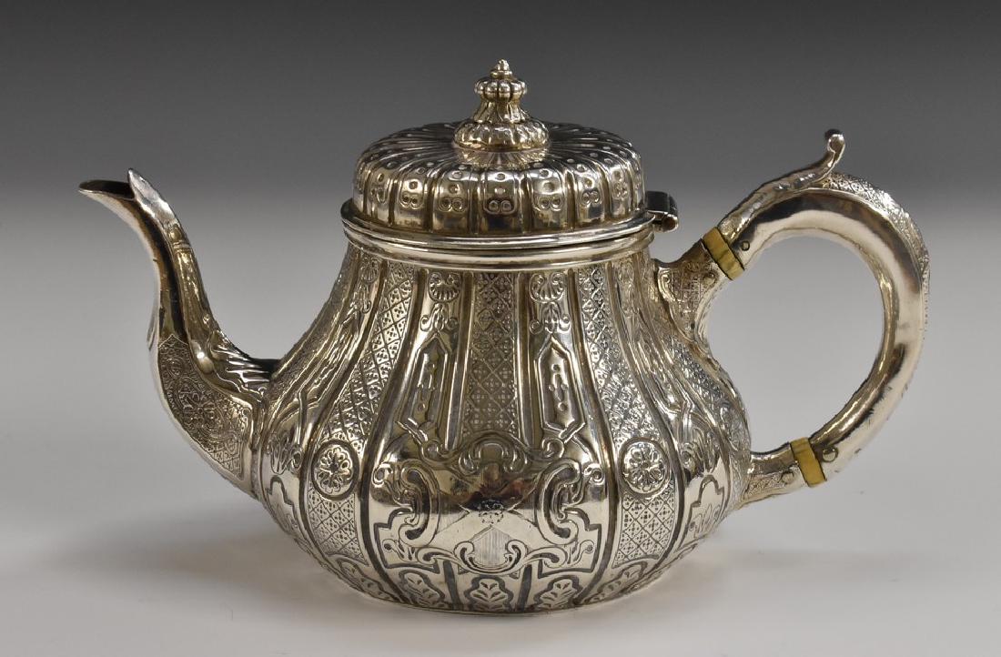 A Victorian Irish silver pear shaped teapot, hinged: A Victorian Irish silver pear shaped teapot, hinged cover with knop finial, chased with alternating bands of strapwork and diapers, scroll-capped handle, 22.5cm long, Robert W Smith, Dublin 1854, 15oz