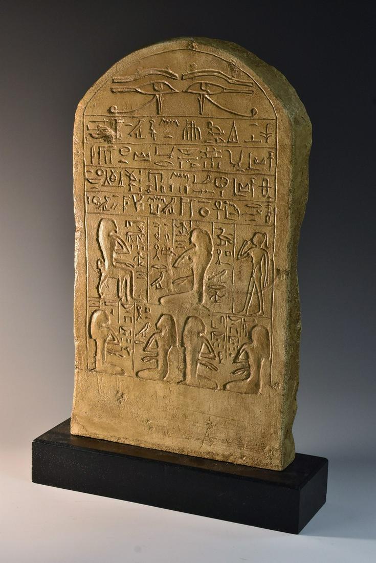 A museum composition copy, of a tablet or stele after: A museum composition copy, of a tablet or stele after the Ancient Egyptian, Atelier de Moulage Des Musees de Seine roundel, rectangular wooden base, 42cm high